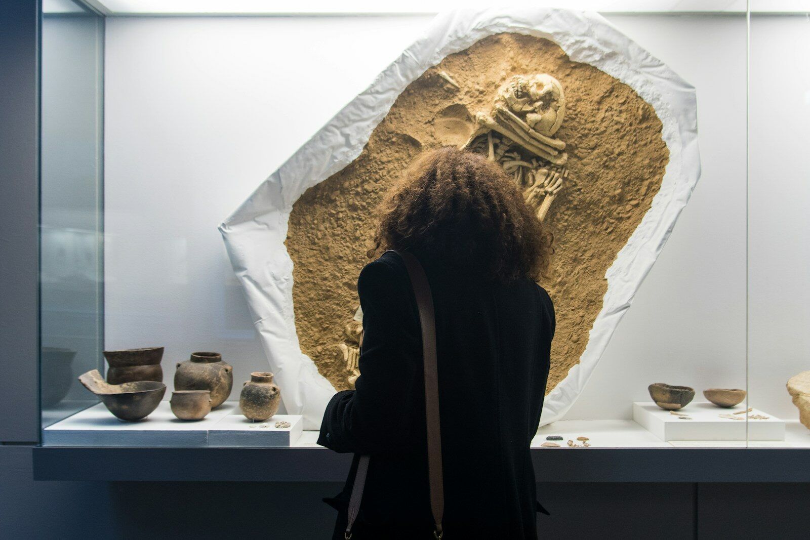 a woman standing in front of a display of pottery
